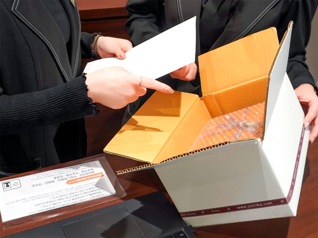 YOCHIKAのスタッフ2名が梱包済みの商品と書類を確認する様子